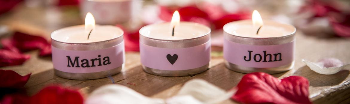 Beleuchtete Kerzen, die mit Namen auf einem rosa Label mit einem Brother-P-Touch-Label und einem Ribbon-Drucker personalisiert sind