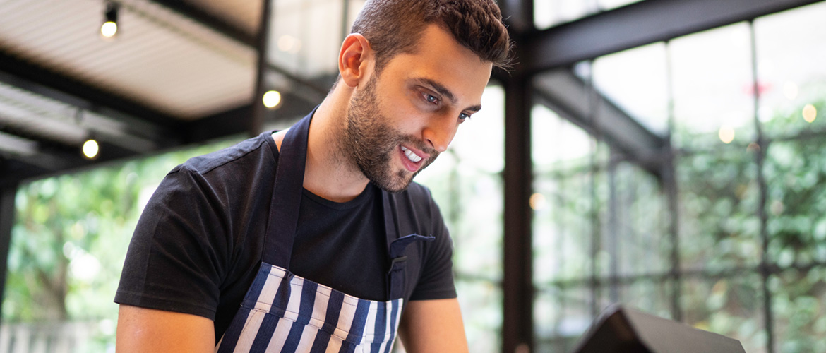 RestaurantMitarbeiter, Lächelnd Bedient Kasse, Restaurant im Hintergrund