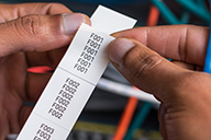 Der Brother PT-E550WNIVP erstellt leicht abziehbare Etiketten, die in einem langen Streifen gedruckt werden, um die korrekte Nummerierungsreihenfolge einzuhalten.