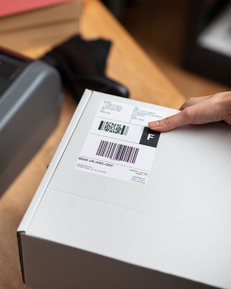 Barcode Etiketten werden auf ein Paket geklebt