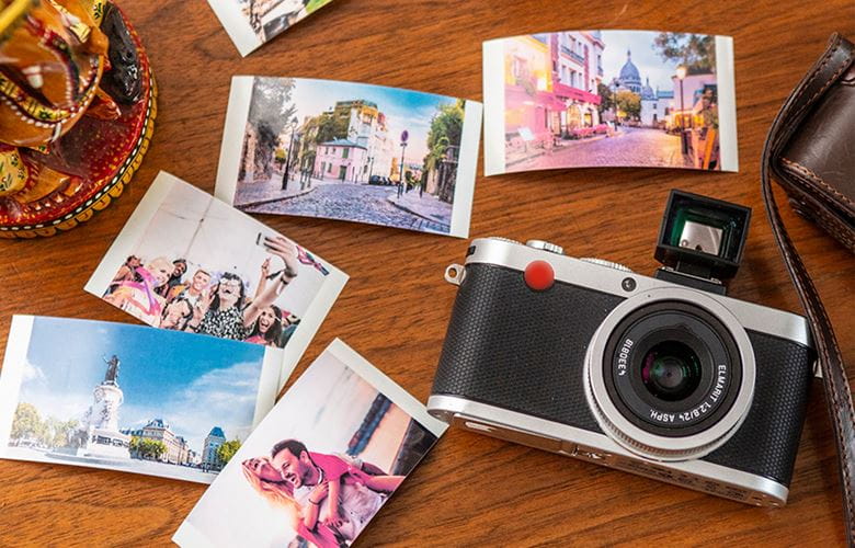 Altes Kameramodell auf einem Tisch mit mehreren Polaroidbildern drum herum