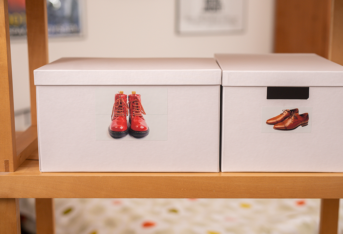 Kisten mit Bildetiketten von verschiedenen Schuhen in einem Regal