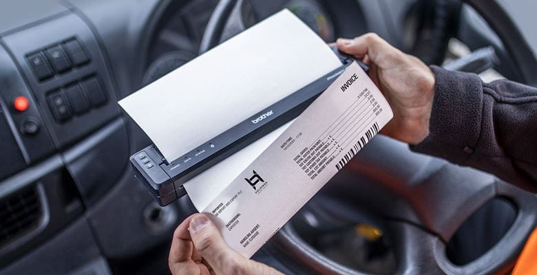 LKW-FAHRER DRUCKT auf Fahrerplatz ein Dokument mit Mobilem Drucker in der Hand-Hand AUS