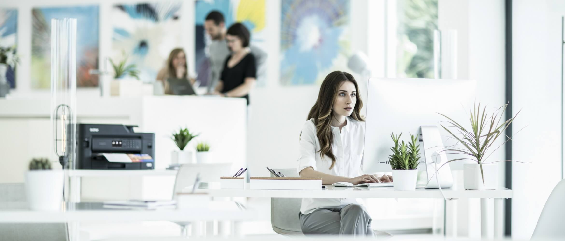 Mujer en oficina mirando pantalla de ordenador