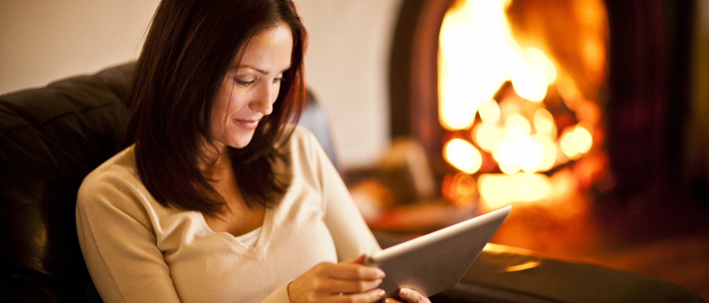 Mujer sentada en sillón mirando tablet