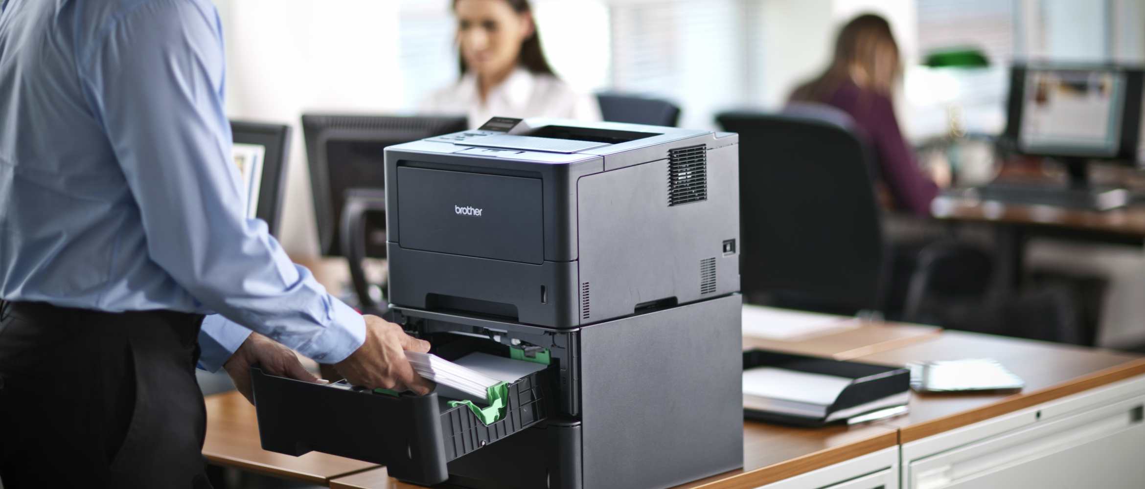 Hombre rellenando papel en impresora