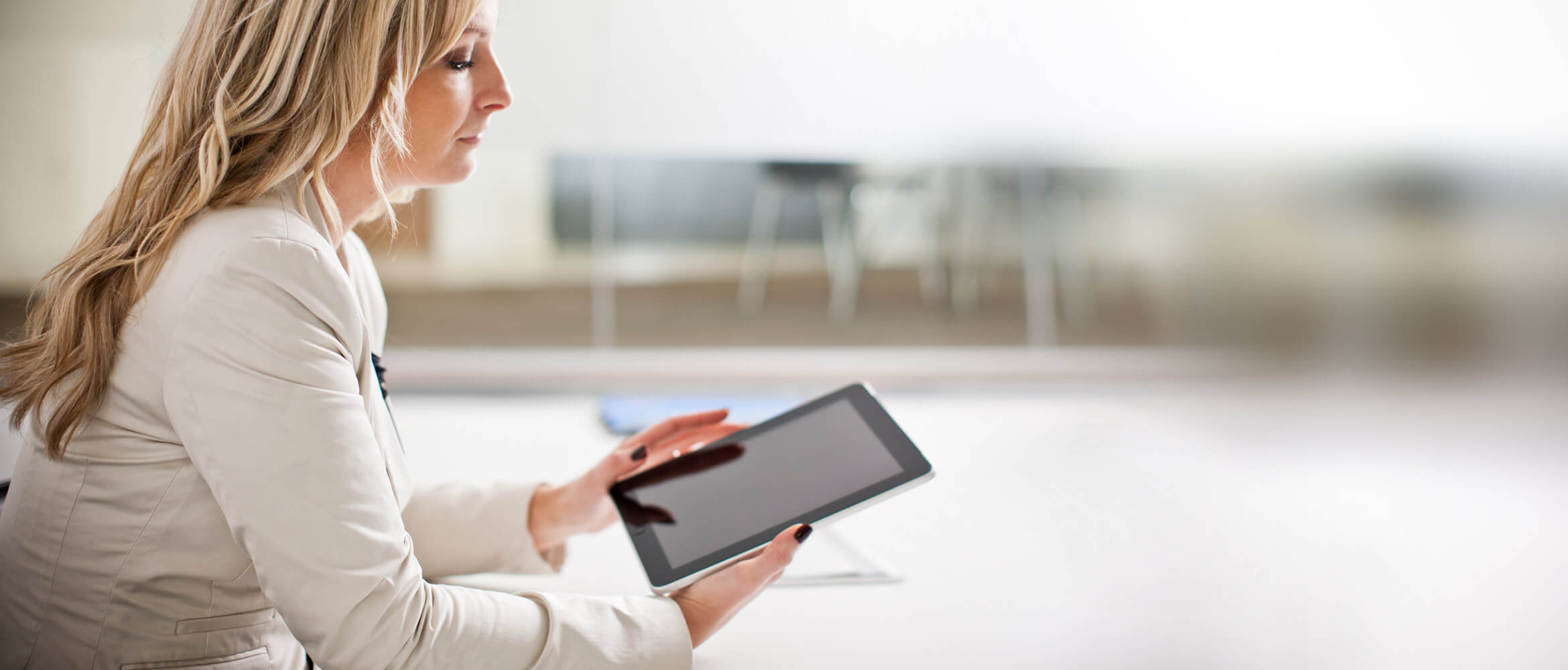 Mujer rubia mirando tablet