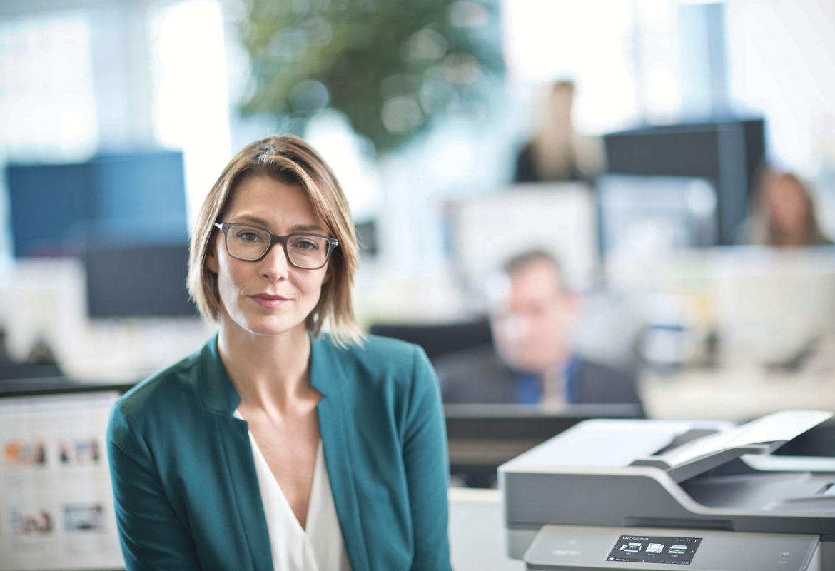 Mujer con gafas junto a impresora Brother