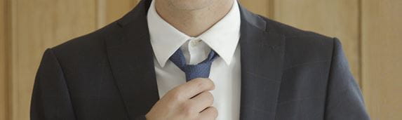 Detalle hombre anudando corbata