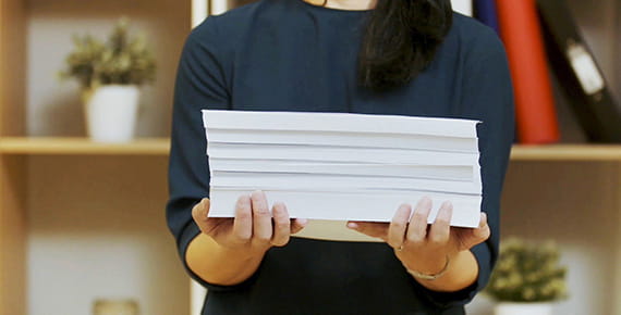 Mujer sosteniendo un taco de documentos