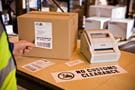 Impresora de etiquetas sobre caja con etiqueta No customs Clearance