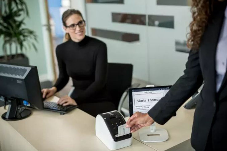 Mujeres en oficina utilizando impresora de etiquetas Brother