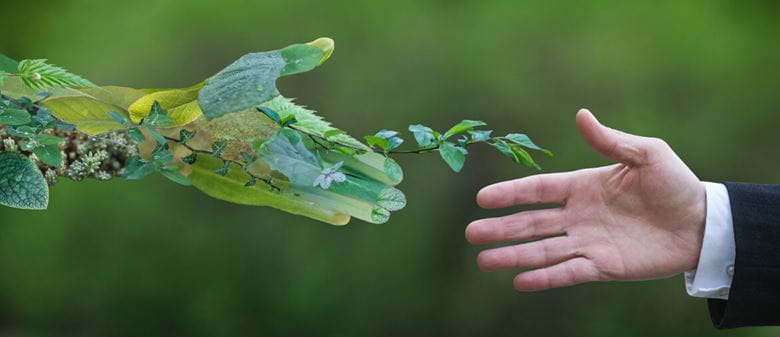 two hands shaking, one a man, one an environmental representation of a hand
