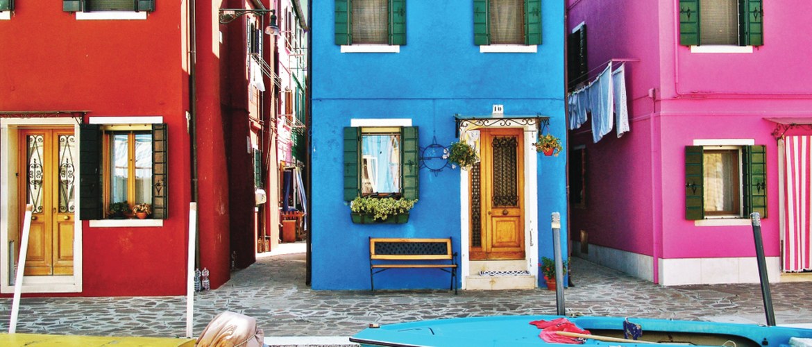 Vibrant coloured red, blue and pink buildings on a street in town