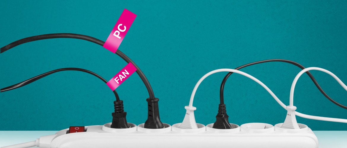 A multi-plug extension in the office has a variety of electrical devices plugged in. Only two of the five are brightly labelled with a bright pink label. They clearly identify a