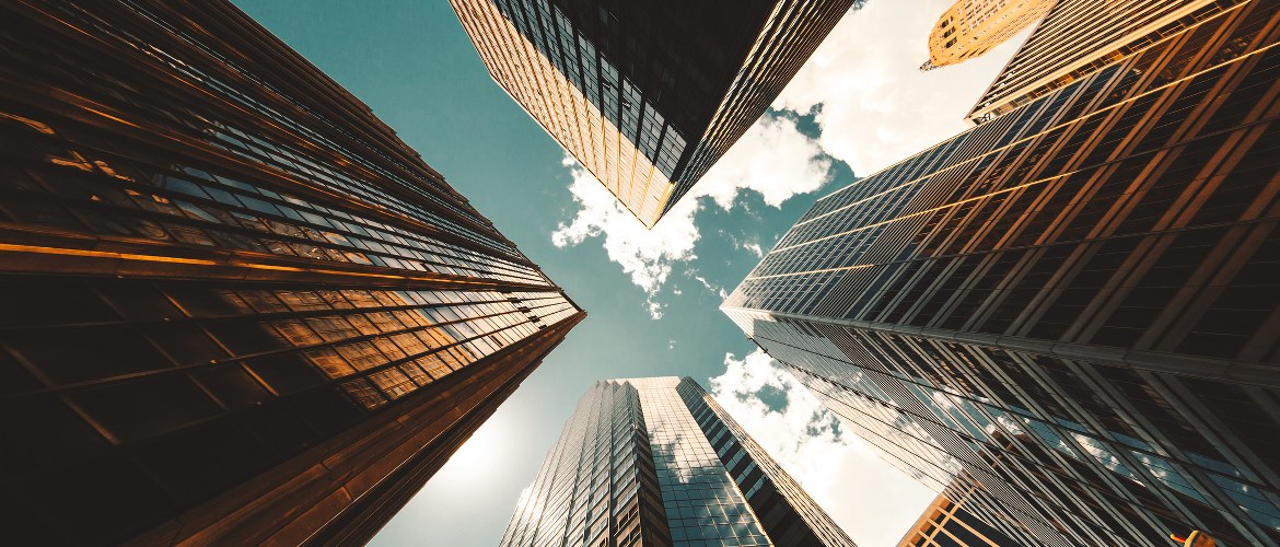 Office of the future image depicting skyscrapers in a city business district from the ground looking up to the sky during the day