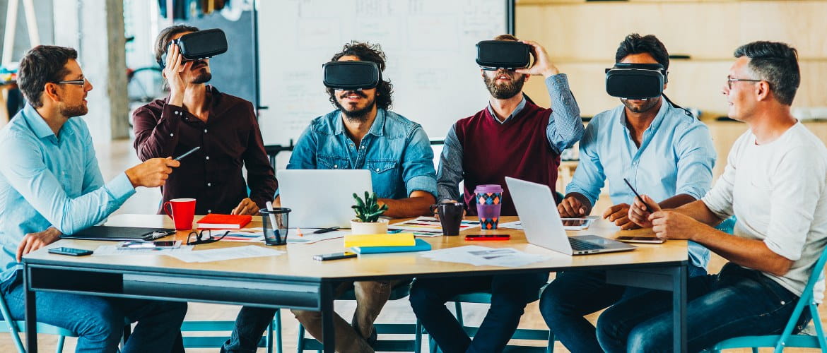 Office of the future - technological backbone image depicting six office workers using VR augmented reality headsets while working through a business meeting