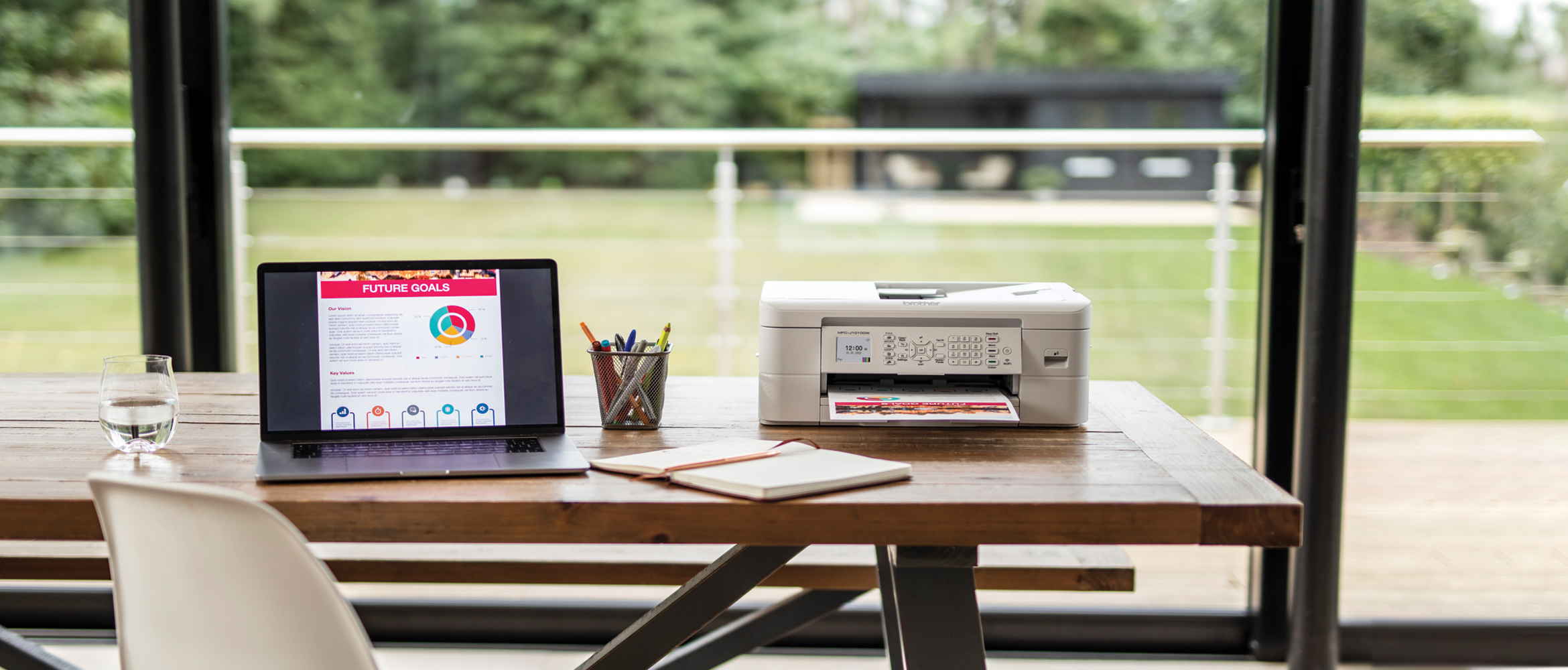 printer sat on a table next to a laptop and notepad