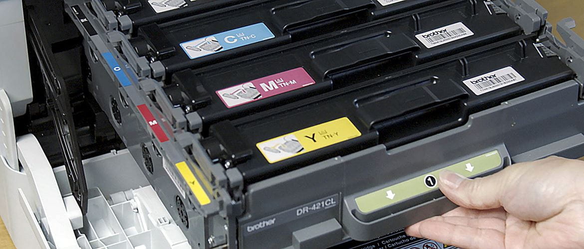 Човек изважда тонер касетите от принтер