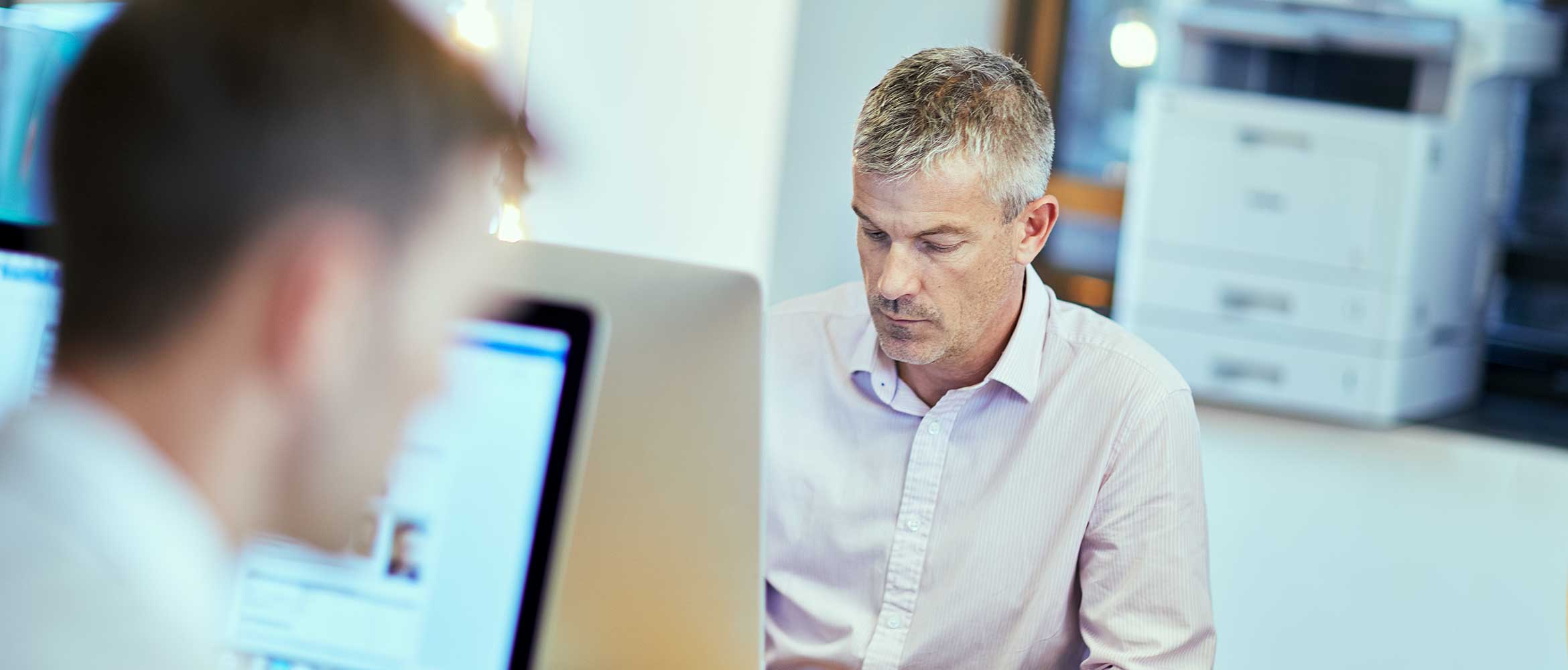 Forretningsmann som arbeider på en datamaskin på et kontor