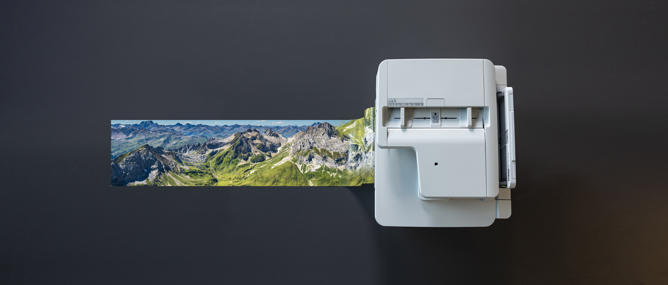Large format printer printing gloss photo with printer on black background