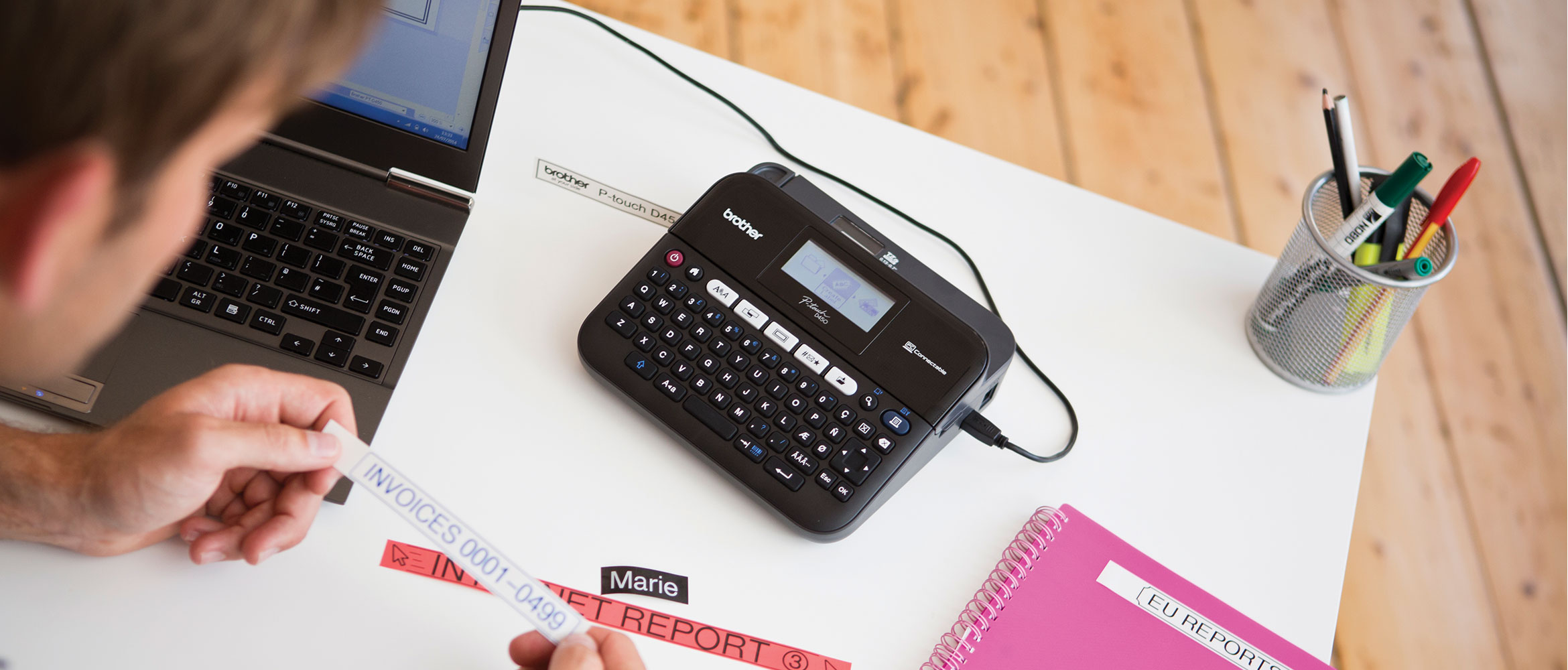 Man using Brother label printer to label invoices at his desk