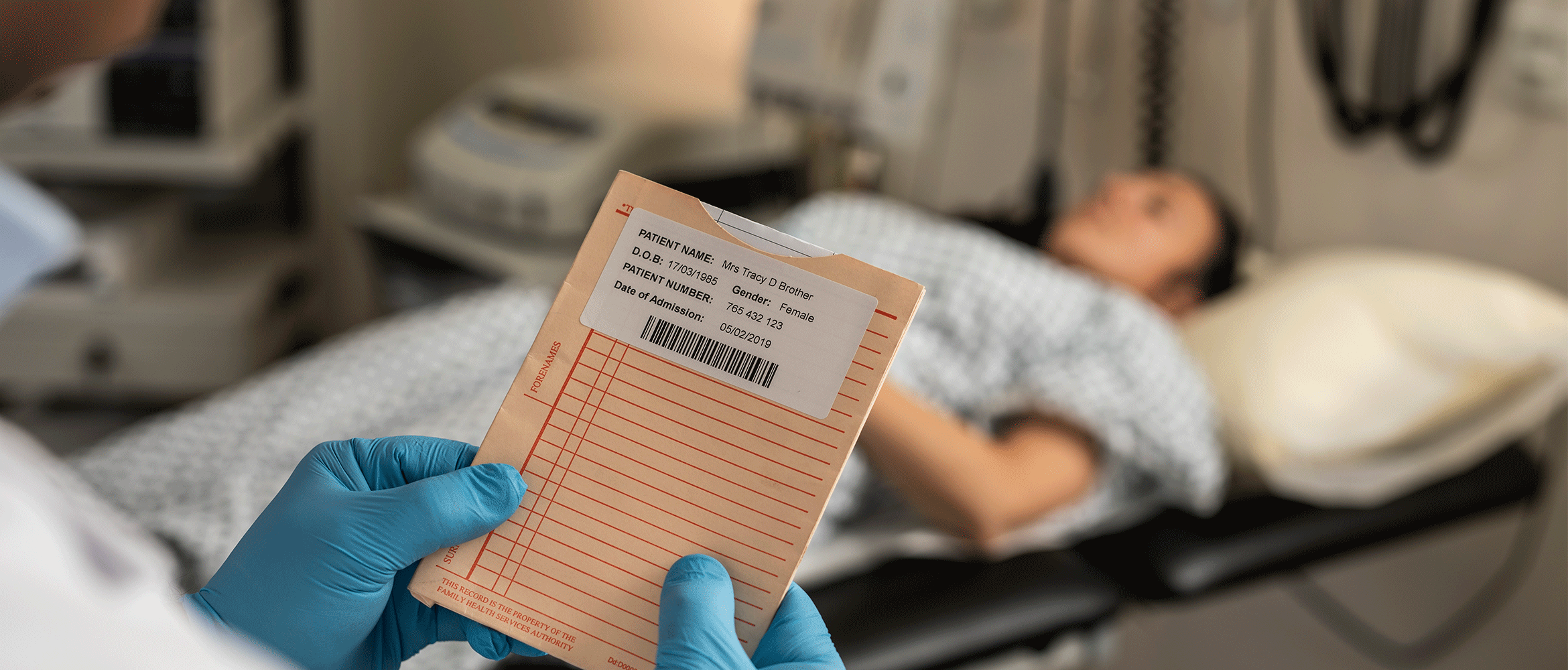 Pacientka ležiaca na nemocničnej posteli, doktor kontrolujúci záznamy