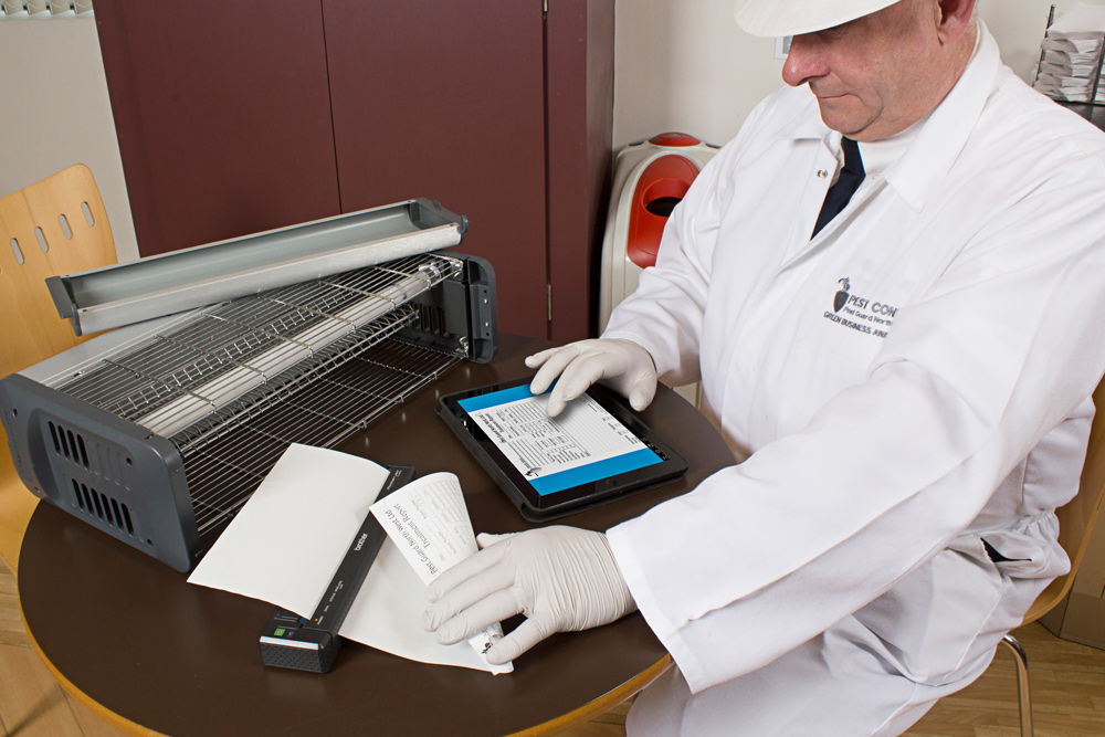 Man with A4 document and handheld mobile device
