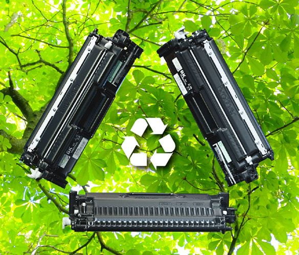 Three toner cartidges in mid-air in a recycling symbol with a background of trees