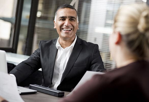 Business man laughing while sat at table with business woman
