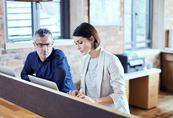 Business man and woman looking at computer screen in office
