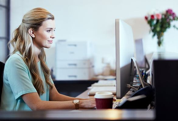 En kvinne på et kontor jobber på datamaskinen