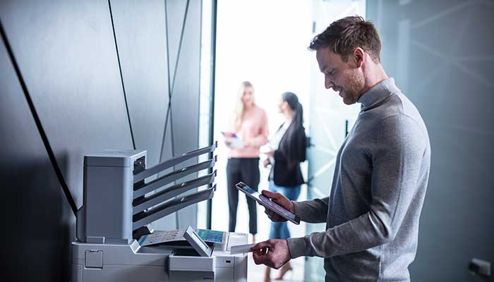 Mand med NFC-kortlæser ved printer