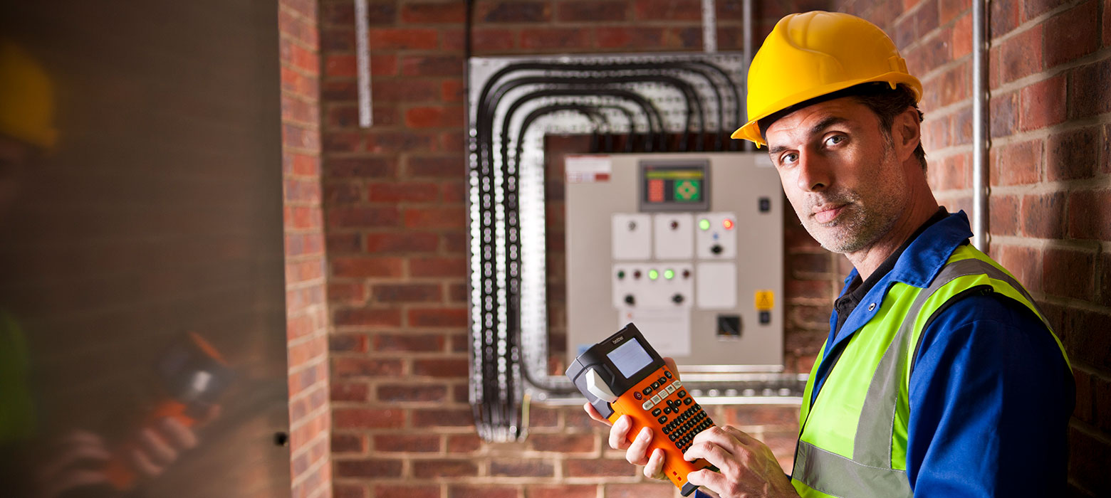 Electrician holding label printer