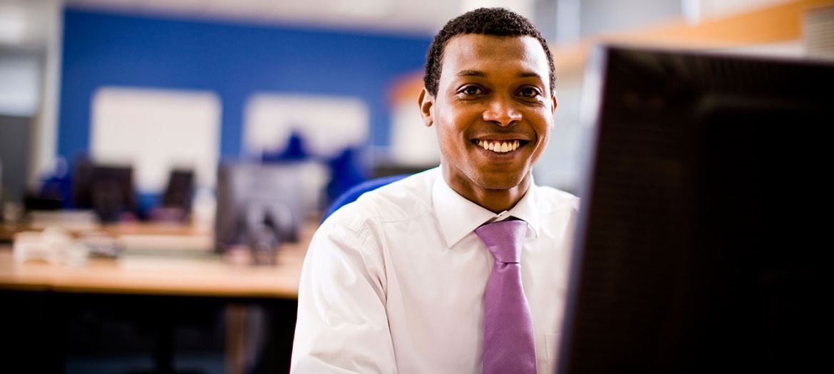 Businessman smiling while at work on his computer