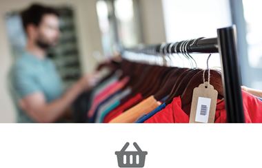 Muškarac u trgovini gleda šarenu odjeću na stupu