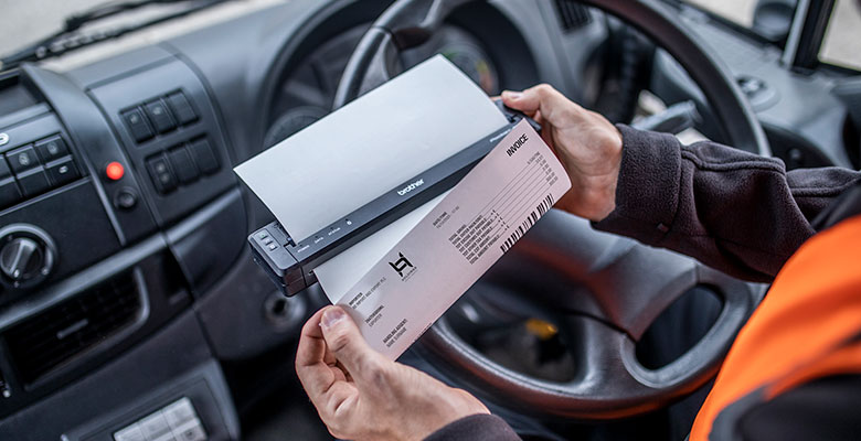 Person som skriver ut et dokument fra en skriver montert i bilen