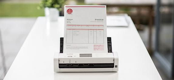 Brother ADS-1700W compact document scanner on desk scanning a document