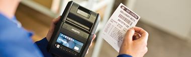 Brother RJ portable label printer with barcode label being printed