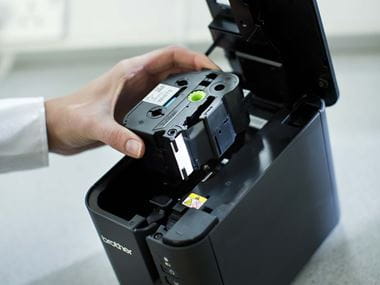 Brother TZe tape cassette being inserted into a PT-P900W label printer