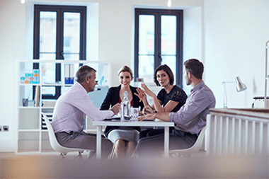 Four business people sitting around a table