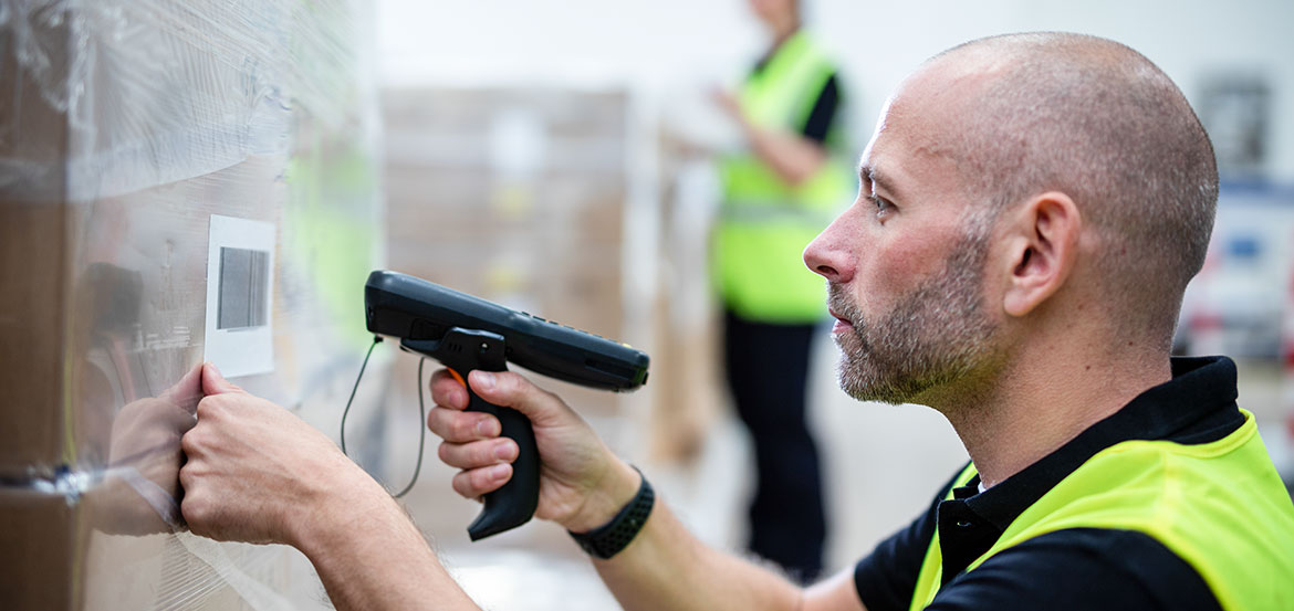 Mand med refleksvest, der scanner en label