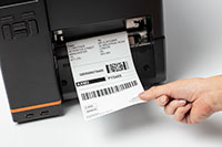 Close up of Brother TJ industrial label printer printing barcode labels