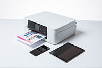White inkjet printer surrounded by mobile devices