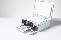 White inkjet printer with colourful output and copy/fax lid open