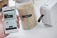 Someone printing labels for glass jars from their smartphone using a Brother P-touch Cube label printer