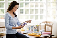 A woman using a P-touch handheld label printer at home