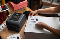 Imprimantă de etichete TD-4T și etichetă de livrare aplicată pe cutie