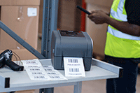 TD-4T label printer on metal trolley with scanner printing labels