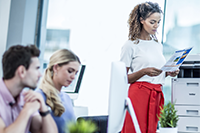 Frau steht neben einem Drucker